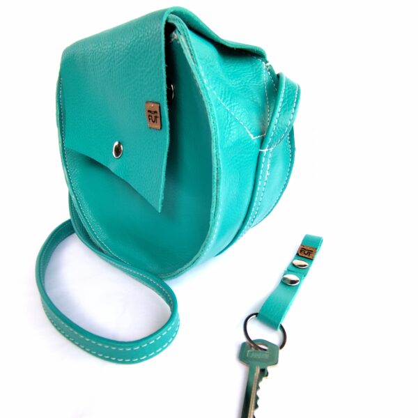 Sac Rond avec rabat et bandoulière en Cuir grainé Bleu. Attache porte-clés inclus.